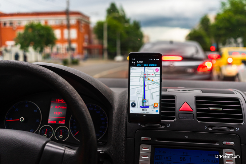 Driving and using waze maps application on smartphone on car dashboard